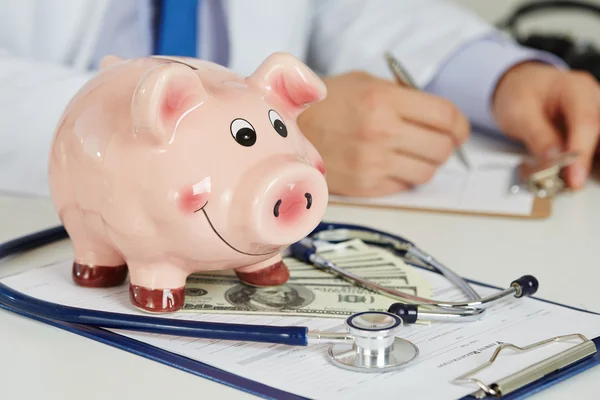 Funny piggybank with document on clipboard — Stock Photo, Image