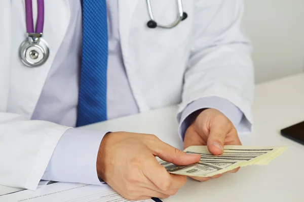 Male medicine doctor holding in hands bunch of hundred dollars b — Stock Photo, Image