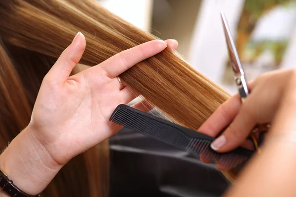 Peluquería femenina en la mano entre los dedos mechón de pelo — Foto de Stock