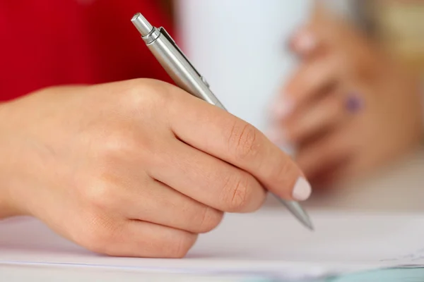 Female hands holding cup of coffee or tea and silver pen closeup — Stock Photo, Image