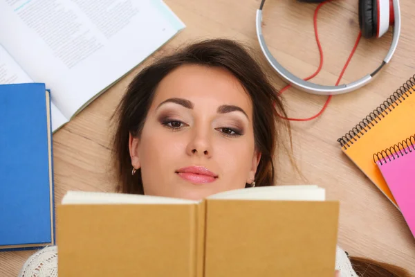 Красива жінка портрет лежить на підлозі читання книги — стокове фото