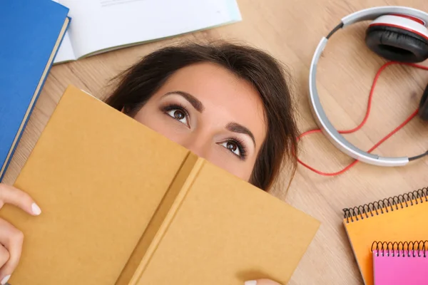 Hermosa mujer acostada en el suelo cubriendo la cara con libro soñando —  Fotos de Stock