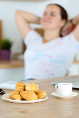 Plate with tasty fresh croissants and hot morning cup of coffee
