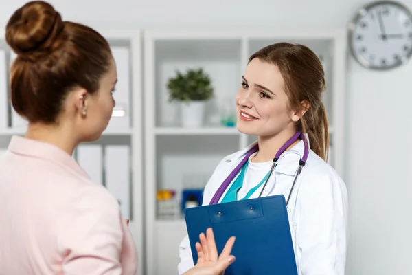 Souriant beau médecin de médecine féminine communiquant et plaisantant — Photo