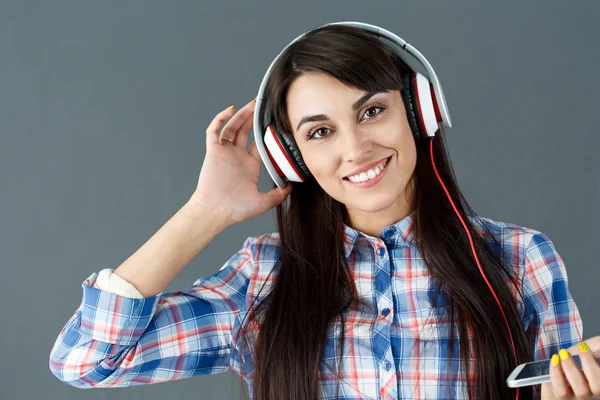 Beautiful dark haired smiling woman wearing headphones — Stock Photo, Image