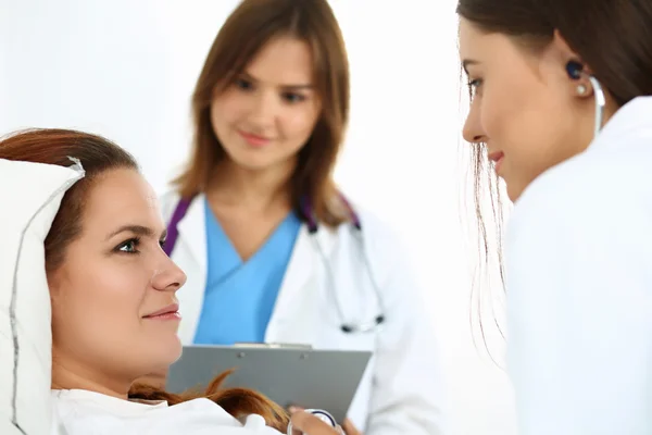 Médico femenino comunicándose, examinando y escuchando con — Foto de Stock