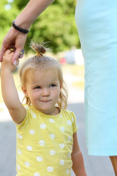 Sorrindo engraçado menina ao ar livre segurando mãe mão retrato — Fotografia de Stock