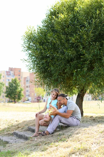 Pais felizes brincando com a filha ao ar livre — Fotografia de Stock