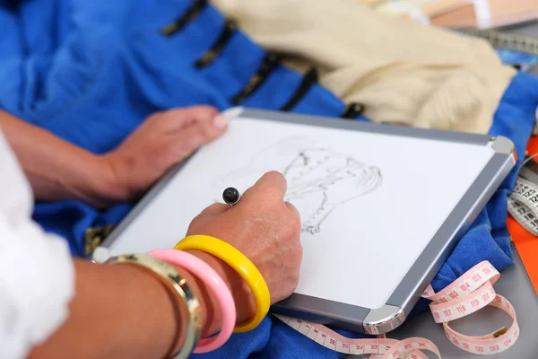 Designer de moda feminina mãos segurando bloco de desenho e caneta fazendo — Fotografia de Stock