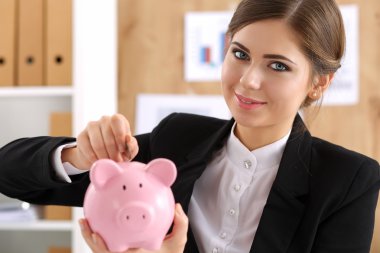 Mutlu gülümseyen güzel iş kadını ve piggybank