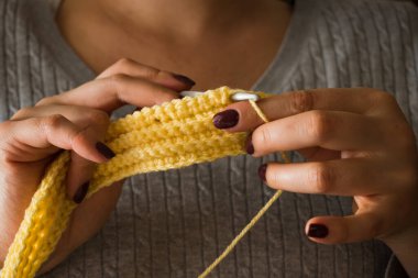 Kadın yün elbiseler örüyor. Örgü iğneleri. Ellerin yakın görüntüsü. Evden çalışıyorum. Doğal yün..