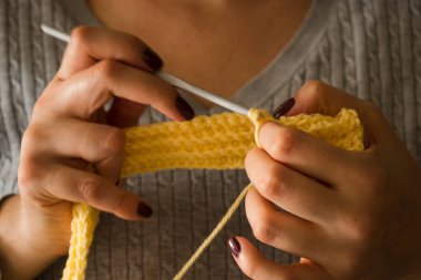 Kadın yün elbiseler örüyor. Örgü iğneleri. Ellerin yakın görüntüsü. Evden çalışıyorum. Doğal yün..