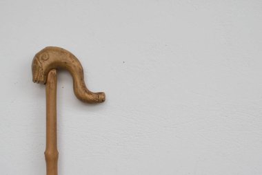 Ahşap çobanın dolandırıcı çoban başı beyaz bir arka planda baston taşıyor. Geleneksel Yunan bastonları.