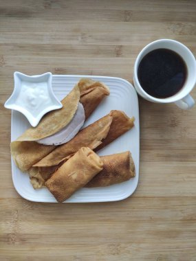 Geleneksel Ukrayna ya da süzme peynirli Rus krepleri ve işlemeli peçetelere ekşi krema