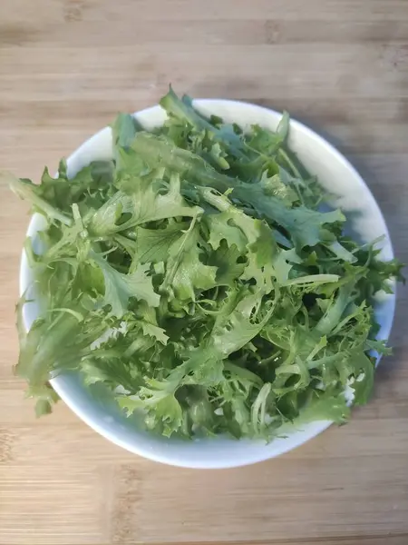 テーブルの上の皿の上に新鮮なサラダの緑 — ストック写真
