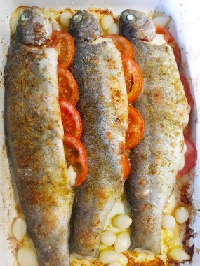 fırında alabalık, domates ve baharat seramik formda.,