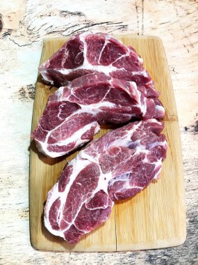 Taze domuz bifteği masada, pişmeye hazır.