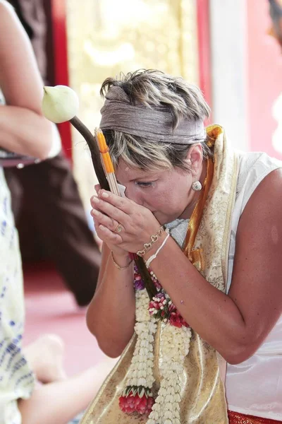 a praying woman in a Buddhist temple at a wedding ceremony