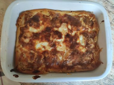 Beyaz tabakta etli, mantarlı ve peynirli turta.