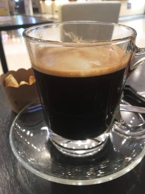 Ahşap arka planda dumanı olan bir fincan kahve.