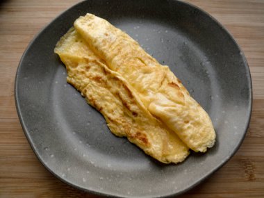 Gri arka planda bir tabakta buğulanmış omlet. Yukarıdan bak. Vejetaryen kahvaltısı. sağlıklı gıda konsepti.