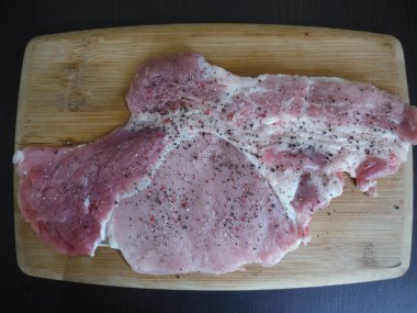 Köy ahşap bir arka planda çiğ domuz pirzolası.