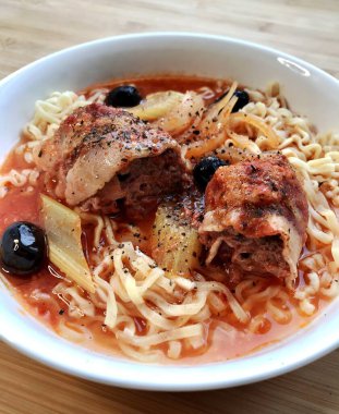 Masadaki beyaz tabakta et ve sebzeli Çin eriştesi.