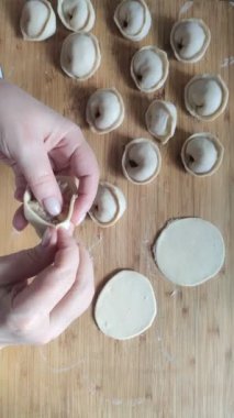 Tahta masada hamur işi yapan bir adamın elleri..
