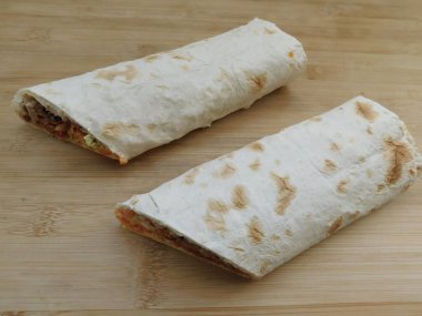 Ev konseptinde mutfak masasında tavuk dürümü pişirme süreci. Ev yapımı kebap yakın çekim. Taze lavaş ya da içinde besleyici maddeler olan bir rulo shawarma sandviçi..