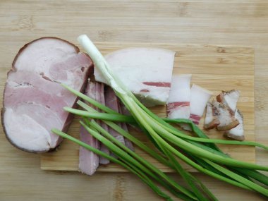 Çavdar ekmeği, yeşil soğan ve biberli domuz pastırması dilimlerini yakından izleyin. Seçici odak, uzayı kopyala. Ülke tarzı organik gıda..