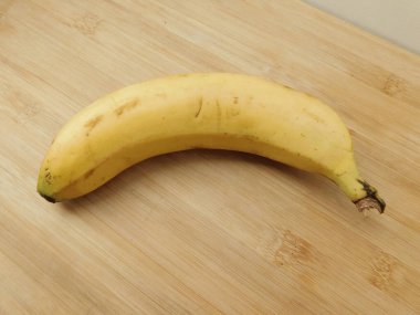 Olgun, yalnız muz eski bir ahşap masada yatıyor..