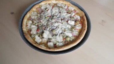 Kırsal ahşap masada ev yapımı pizza.
