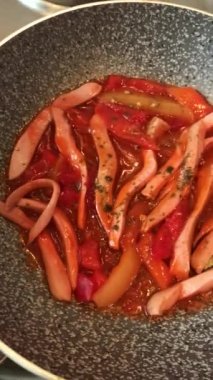 Lezzetli, sulu, geleneksel Akdeniz yemeği Shakshuka. Tahta kesme tahtasının üstünde, siyah bir tavada. Domates ve sahanda yumurta, baharatlar. Üst görünüm kapat.