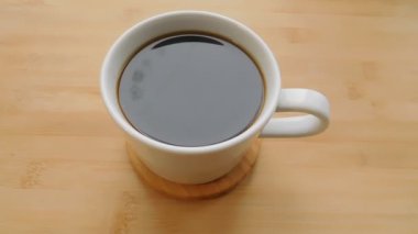 Ahşap masa arkasında kahve fincanı manzarası.