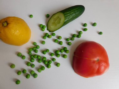 Masada taze organik domates, salatalık, limon ve bezelye var. sağlıklı bir diyetin temeli.