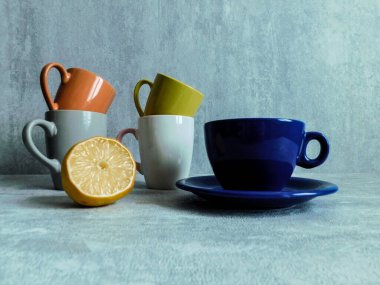 Renkli kupalar ve ahşap bir masada yarım limon.