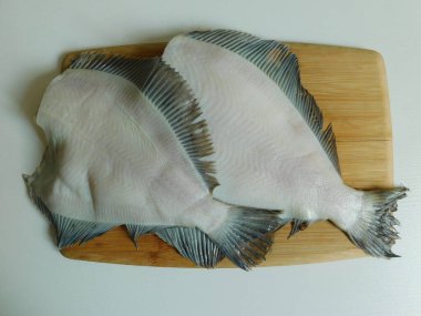 İki taze dil balığı, büyük ve küçük, pişirmeden önce.