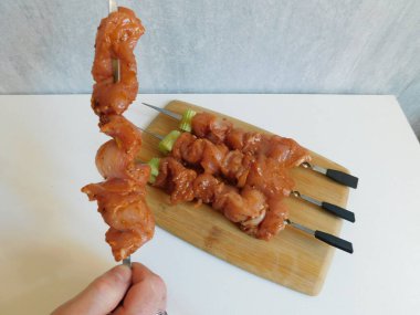 Şiş kebap hazırlığı için. Kızın eli şişe çiğ et koyma sürecinde.