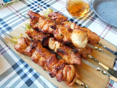 Ahşap bir masada kızarmış tavuk şişi..