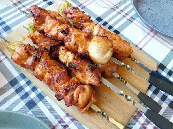 fried chicken skewer on skewers on a wooden table.