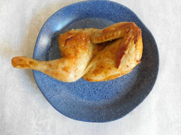 Mitad Del Pollo Parrilla Está Plato Azul Sobre Mesa —  Fotos de Stock