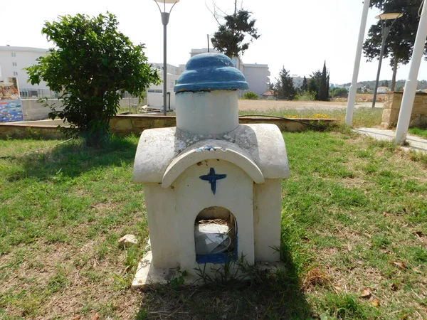 Een kleine kerk en klokkentoren omringd door olijfbomen in het centrum van Protaras, Cyprus. — Stockfoto