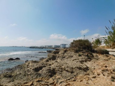 Kayalık deniz kıyısı ve mavi gökyüzü. Kıbrıs. Protaras. Nisan 2021.