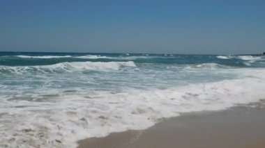Kumlu sahilde dalgalar. İncir ağacı kumsalı. Protaras. Ayia Napa. Kıbrıs.