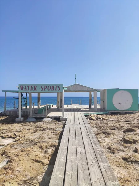 Drewniana ścieżka do morza na tle błękitnego nieba. Protaras. Cypr. kwiecień 2021 — Zdjęcie stockowe