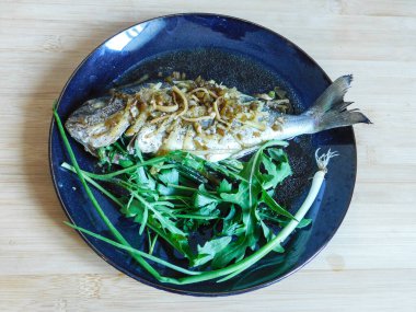 Tayland tarifine göre Dorado balığı zencefil, soya ve taze otlarla pişirilmiş istiridye sosu. Asya mutfağı