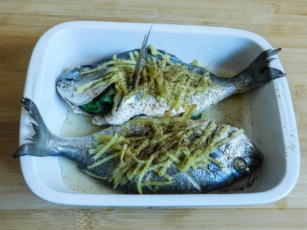 Pesce dorado cucinato con zenzero, soia e salsa di ostriche con erbe fresche secondo una ricetta tailandese. Cucina asiatica. — Foto Stock