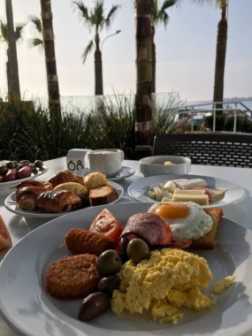 Sahildeki otelin terasında jambonlu çırpılmış yumurta ve kahve kahvaltısı. Protaras. Ayia Napa. Kıbrıs