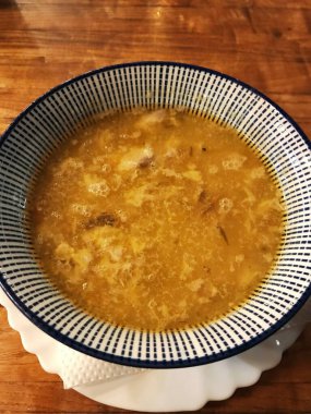 Parlak kırmızı masa örtülerinden oluşan bir tabak çorba. Geleneksel Bulgar süsüsüyle dolu bir tabak baharatlı çorba. Restoranda çorba. Bulgar yemeği. Seçici odak.