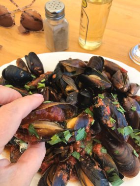 Restoranda bir tabakta şarap ve otla pişirilmiş midye. Balchik. Bulgaristan.